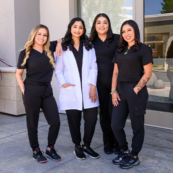 Dentist and team outside office smiling