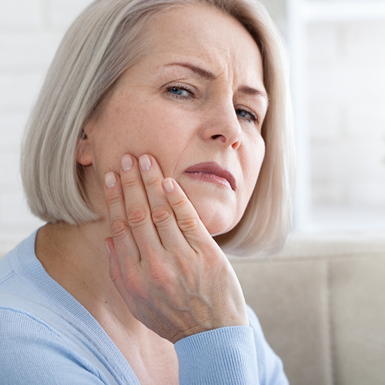 Close up of woman rubbing her jaw in pain