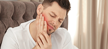 Man rubbing his jaw in pain