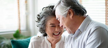 Senior man and woman leaning against each other on couch