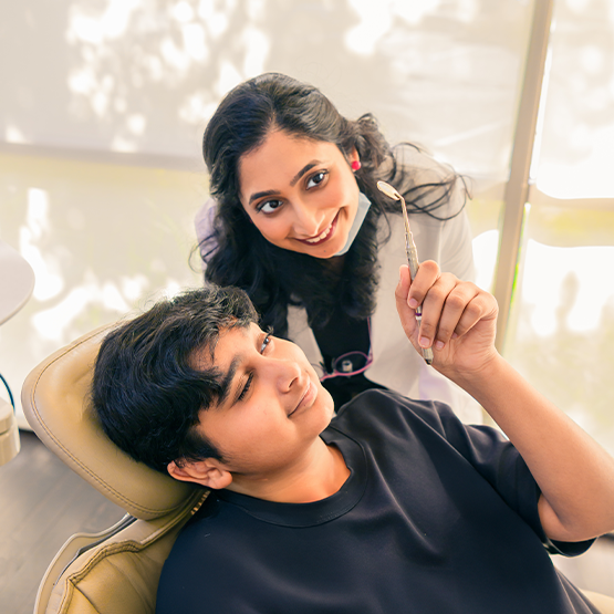 Dentist watching while child checks smile in mirror