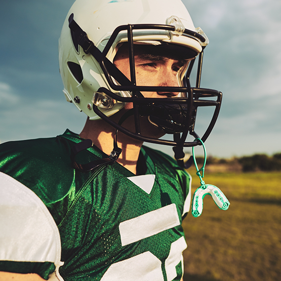 Child wearing football helmet with mouthguard